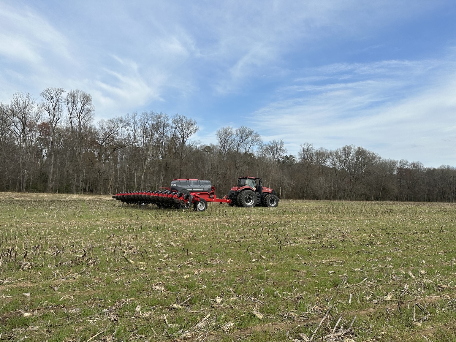 Tractor and planter crossing a residue-covered field