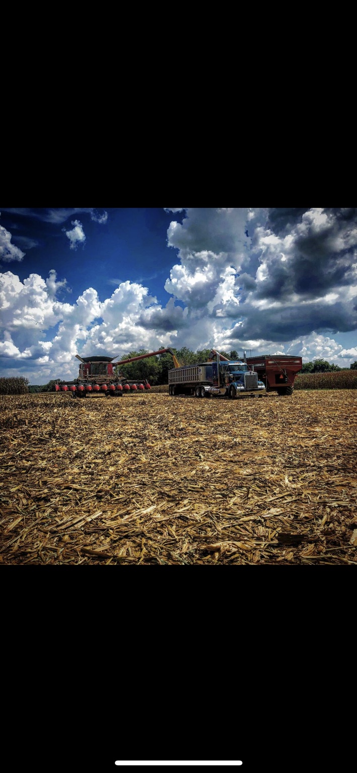 Tractor working crop residue beneath a dramatic sky