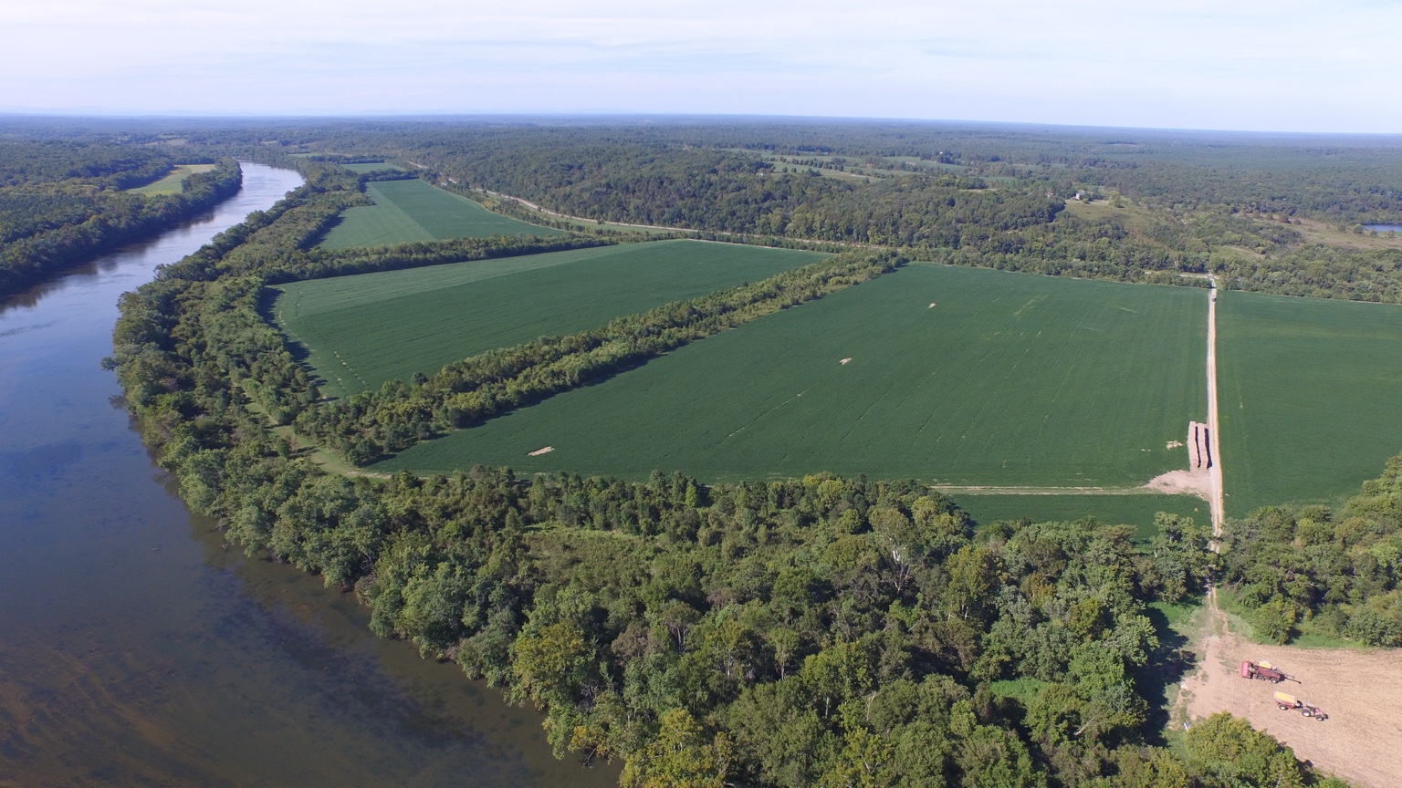 Aerial view of green fields beside a winding river