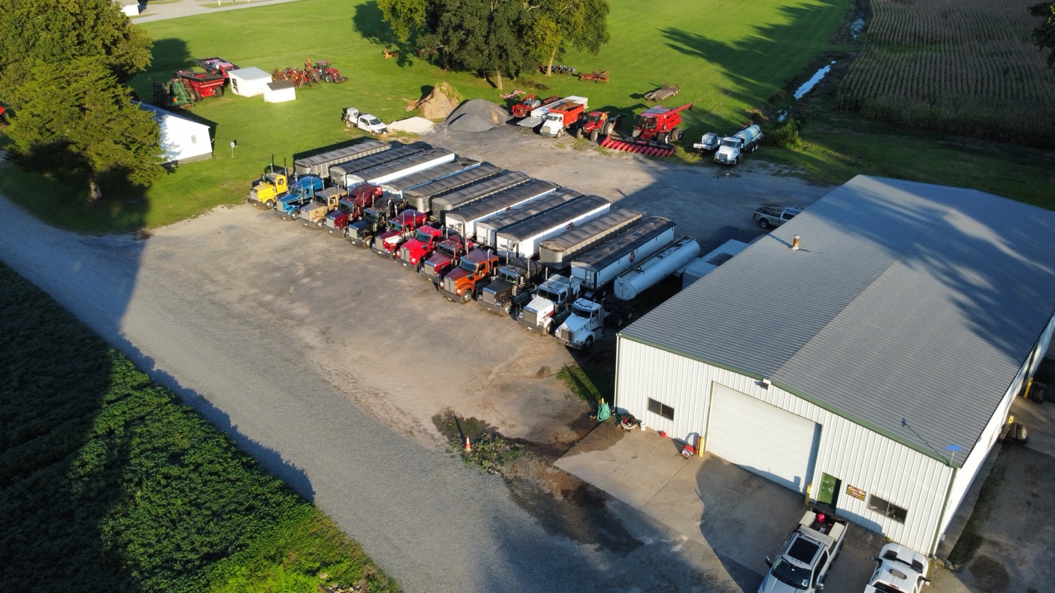 Fleet of grain trucks lined up beside the farm shop